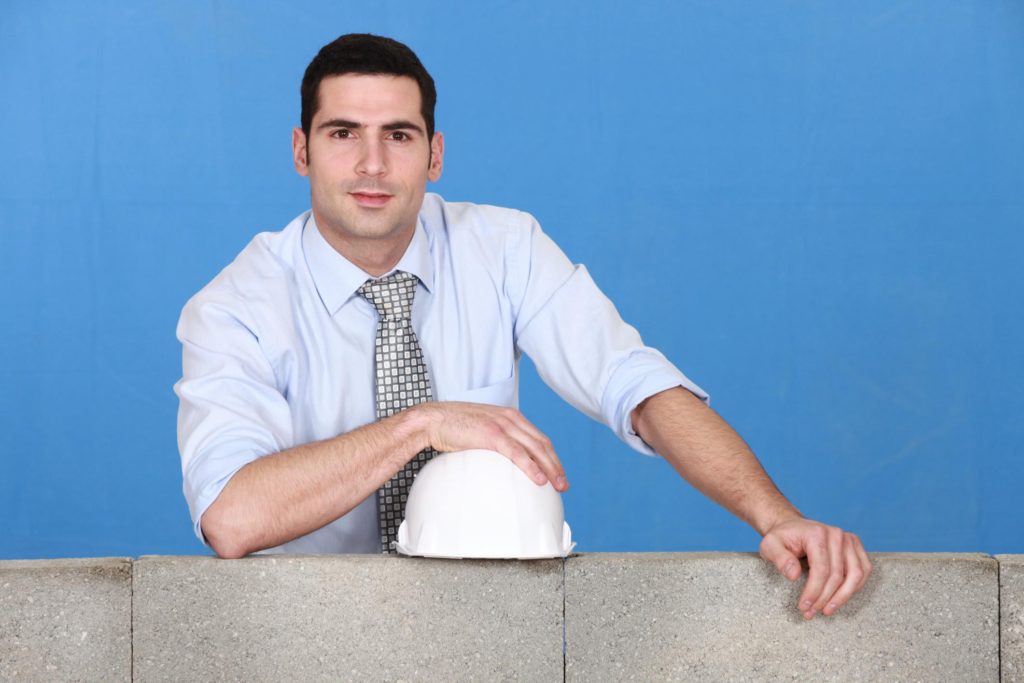 man in his office suit and holding a safety helmet