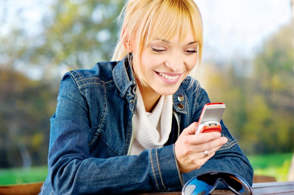 girl smiling while looking at her phone